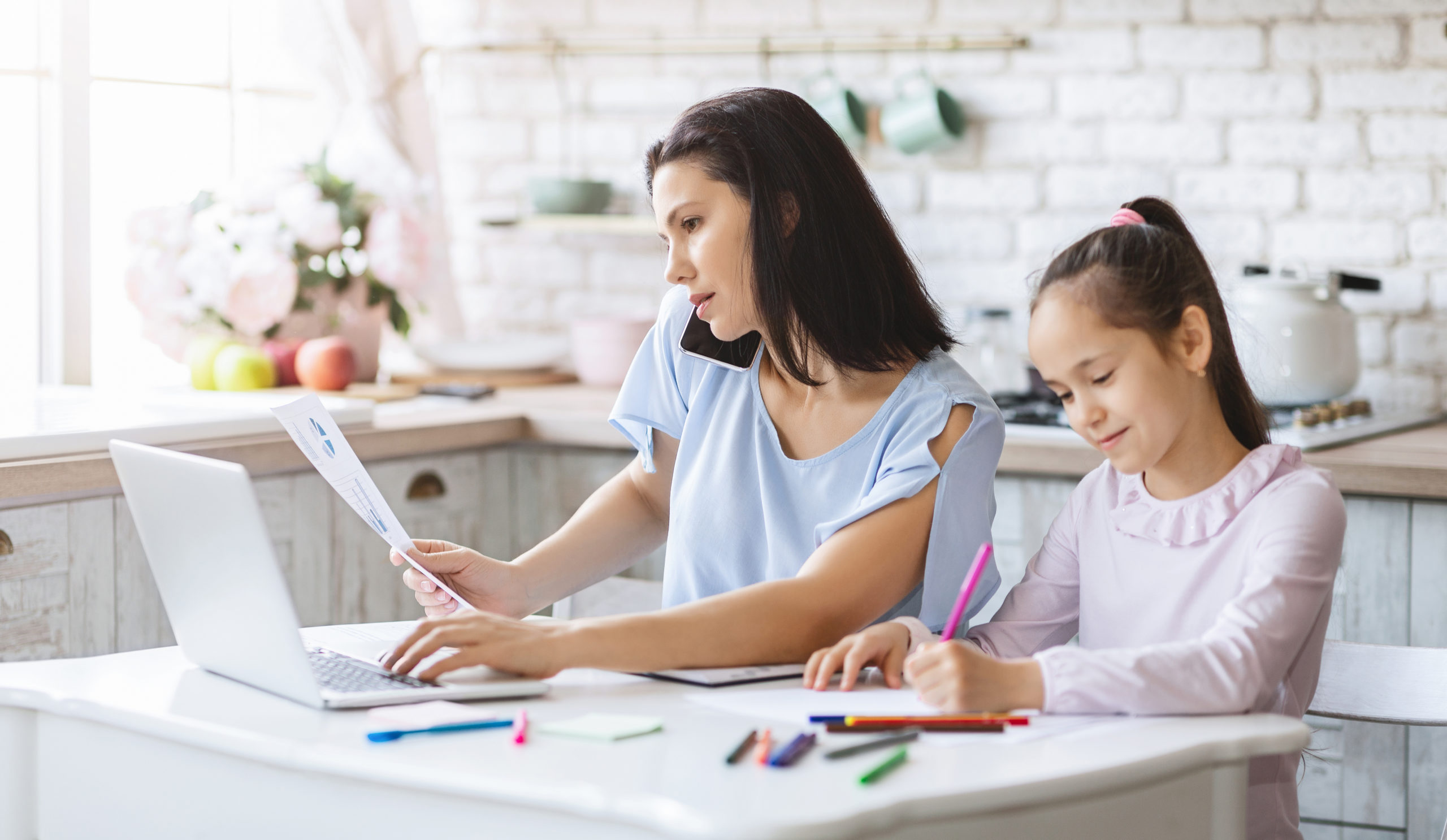 Mother working from home while daughter doing homework in kitchen Disadvantages Of Working From Home